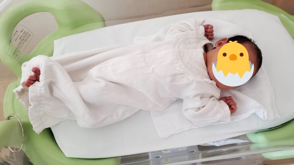 コットの上で足を伸ばして寝ている赤ちゃん